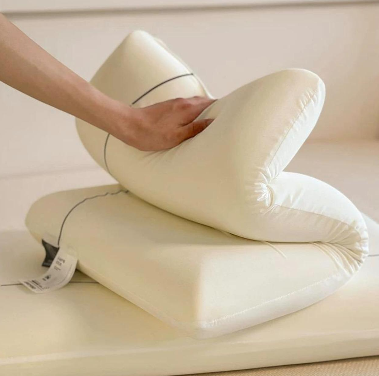 Almohada Nubara™ doblada con la mano, mostrando la flexibilidad de la espuma